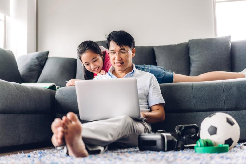 asian dad and his daughter looking at a computer together