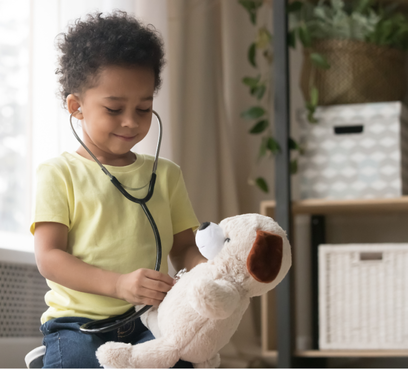 young kid using a stethoscope on teddy bear young kid using a stethoscope on teddy bear